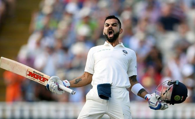 Virat Kohli in Indian Test whites roaring in celebration with MRF bat and helmet held out wide after scoring his defiant 149 at Edgbaston in August 2018